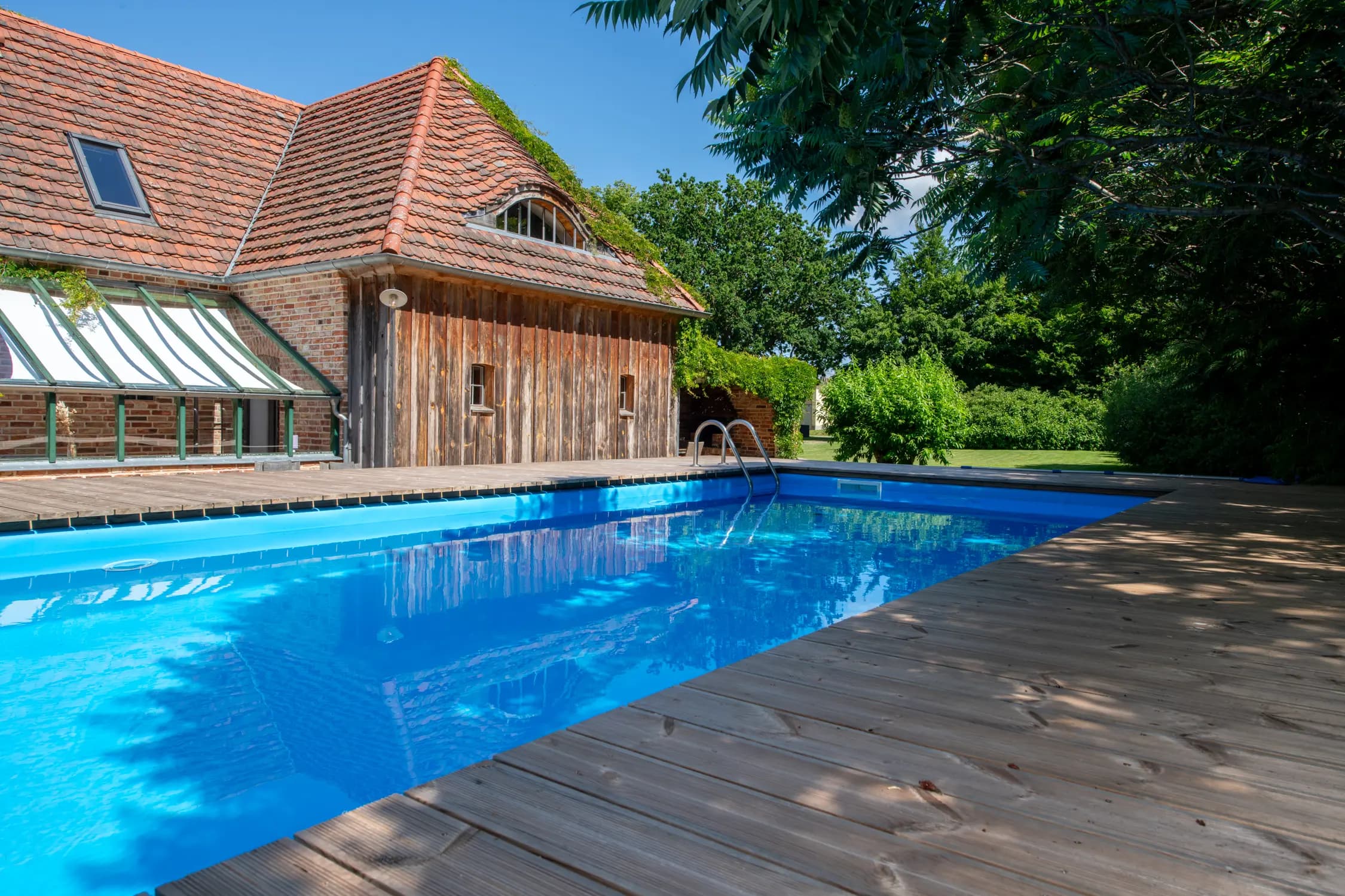 Großer Poolbereich mit Sonnenliegen für entspannte Urlaubstage, Ferienhaus Welzin
